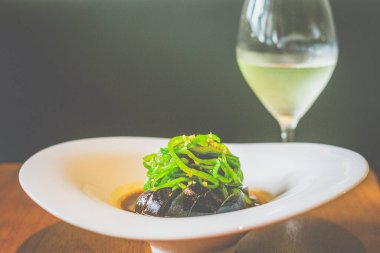 Beyaz tabakta servis edilen ızgara biberli yüzyılın dilimleri.