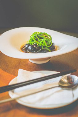 Beyaz tabakta servis edilen ızgara biberli yüzyılın dilimleri.