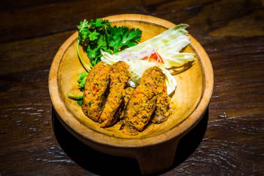 Hindistancevizi füme Chinag Rai köri sosisi bir kasede servis edilir.