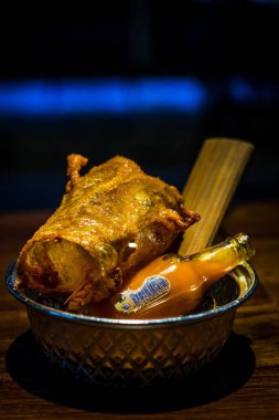 Bir parça ev yapımı See-ra-cha soslu kızarmış tavuk derisi.