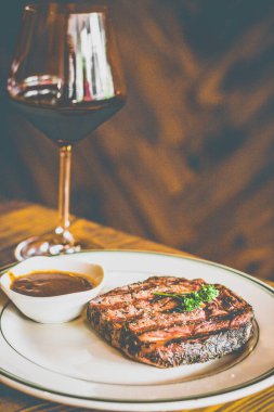 Izgara NZ Angus bifteği, ev yapımı kahverengi sos ve kırmızı şarapla servis edilir.