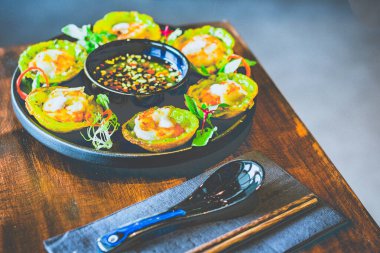 Bir tabakta karides ve hindistan cevizi kremalı mini Vietnam gözlemesi.