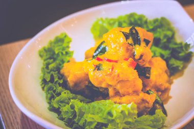 Yağda kızartılmış karidesli tereyağlı sos beyaz bir tabakta servis edilir.