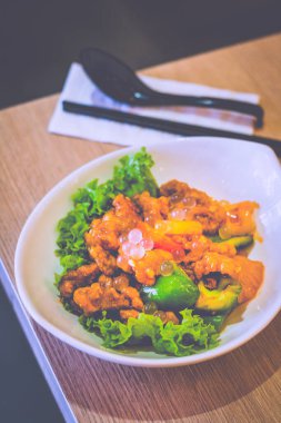 Tatlı ve ekşi domuz eti, marul, dolmalık biber ve liçi incileri.