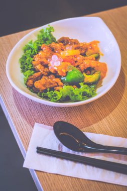 Tatlı ve ekşi domuz eti, marul, dolmalık biber ve liçi incileri.