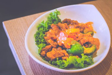 Tatlı ve ekşi domuz eti, marul, dolmalık biber ve liçi incileri.