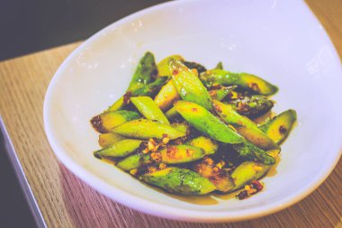 Kızarmış kuşkonmaz ve soslu beyaz bir tabakta servis ediliyor.