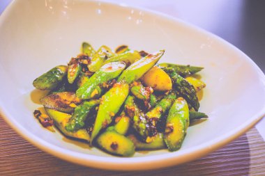 Kızarmış kuşkonmaz ve soslu beyaz bir tabakta servis ediliyor.