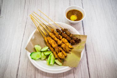 Çin usulü BBQ satay yanında doğranmış çiğ salatalık ve doğranmış çiğ soğan ve fıstık sosu.
