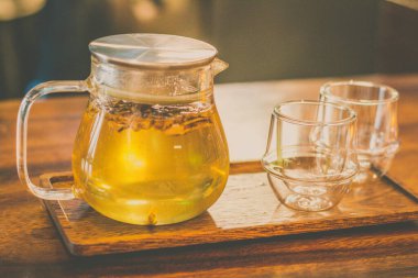 Şeffaf bir çaydanlıkta kavrulmuş Bellflower çayı ve iki küçük bardak