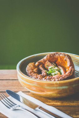Yorkshire Pudingi bir seramik kasede servis edilen biftek, sos ve yaban turpundan yapılır.