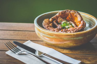 Yorkshire Pudingi bir seramik kasede servis edilen biftek, sos ve yaban turpundan yapılır.