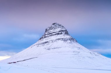 Kirkjufell Dağı, İzlanda. Kış doğal manzarası. Gökyüzü arka planındaki dağ. Kar ve buz. İzlanda 'da seyahat etmek için popüler bir yer.