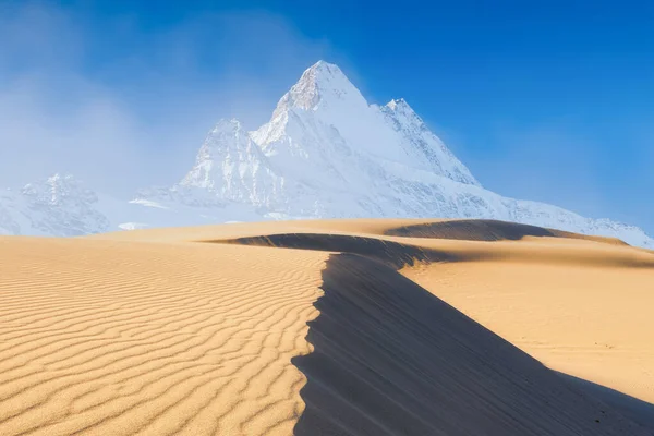 Nature. Sand dunes in the evening and mountains among the clouds. Summer landscape in the desert. Hot weather. Lines in the sand. Mountain range through the fog.
