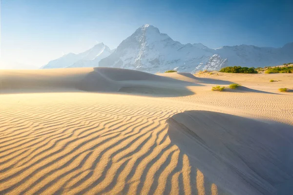 Nature. Sand dunes in the evening and mountains among the clouds. Summer landscape in the desert. Hot weather. Lines in the sand. Mountain range through the fog.