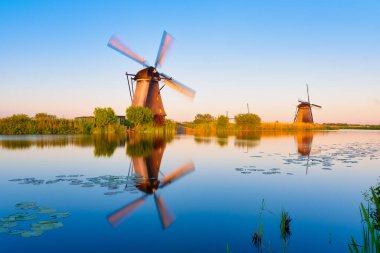 Hollanda 'daki Kinderdijk Ulusal Parkı. Alacakaranlıkta yel değirmenleri. Tarihi bir yerde doğal bir manzara. Su yüzeyindeki yansımalar. Hollanda kanalları. UNESCO Dünya Mirası Alanı.