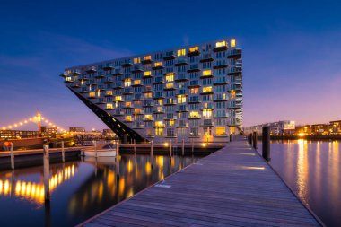 Amsterdam, Netherlands. A cityscape during sunset. A apartment building near the water in the bay. Architecture of the Netherlands. Travel photography.