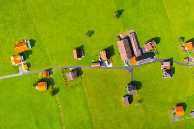 Köyün ve sokakların havadan görüntüsü. İnsansız hava aracının kırsal manzarası. Kiremitleri olan evlerin çatıları. Yazın insansız hava aracının manzarası