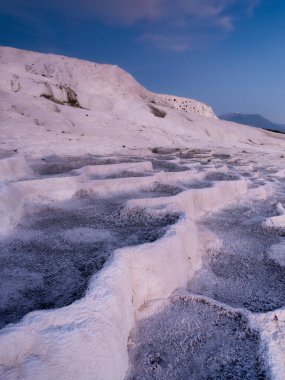 Gün batımında yaz manzarası. Travertin manzarası ve parlak günbatımı. Kalsiyum terasları susuz. Turizm için popüler bir yer. Beyaz kayalar ve günbatımı. Pamukale, Türkiye. 