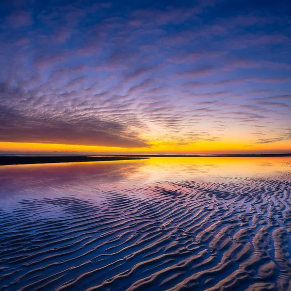 Een Zeegezicht Bij Zonsondergang Lijnen Zand Aan Kust Heldere Hemel — Stockfoto