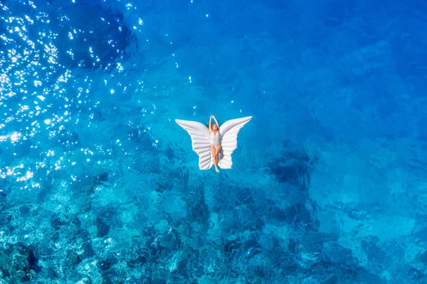 一个女孩的航拍照片 在海滩上休息 用一只充气蝴蝶游泳 海上放松和旅行 海水是蓝色的 暑假里阳光灿烂的一天 — 图库照片