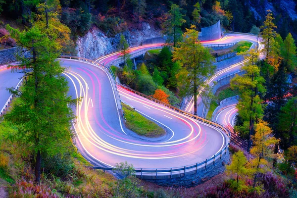 スイスのマロハの峠 森の中にカーブが多い道 輸送だ 車の照明のぼかし 夜の風景 休暇と旅行に — ストック写真