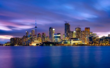 Toronto, Kanada. Gökdelenlerin ve CH kulesinin manzarası. Akşamları şehir merkezi manzarası. Şehrin gece karanlığında aydınlanması. Gölün kıyısındaki şehir. Gün batımında şehir manzarası.