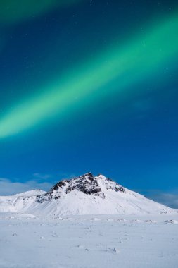 Aurora Borealis. Kuzey ışıkları ve açık gökyüzü. Doğa. İskandinav ülkeleri. Dağlarda kar ve buz. Kış zamanı manzara. Arkaplan ve duvar kağıdı için fotoğraf.