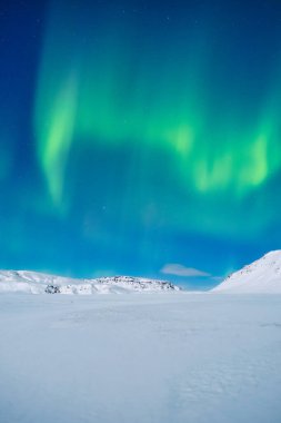 Aurora Borealis. Kuzey ışıkları ve açık gökyüzü. Doğa. İskandinav ülkeleri. Dağlarda kar ve buz. Kış zamanı manzara. Arkaplan ve duvar kağıdı için fotoğraf.