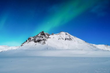 Aurora Borealis. Kuzey ışıkları ve açık gökyüzü. Doğa. İskandinav ülkeleri. Dağlarda kar ve buz. Kış zamanı manzara. Arkaplan ve duvar kağıdı için fotoğraf.