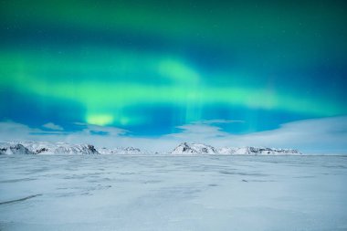 Aurora Borealis. Kuzey ışıkları ve açık gökyüzü. Doğa. İskandinav ülkeleri. Dağlarda kar ve buz. Kış zamanı manzara. Arkaplan ve duvar kağıdı için fotoğraf.