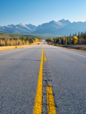 Boş bir yol ve dağlar. Arabayla seyahat edilecek bir yer. Dağlardaki doğal dağ manzarası. Asfalt ve bölme şeritleri. Kartpostallar, arkaplan ve duvar kağıtları için fotoğraf. 