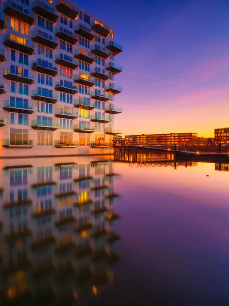 Amsterdam, Netherlands. A cityscape during sunset. A apartment building near the water in the bay. Architecture of the Netherlands. Travel photography.