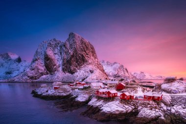 Norveç 'in Lofoten Adaları' ndaki Hamnoy köyündeki eve bakın. Mavi saatte kışın manzara manzarası. Dağlar ve su. Seyahat resmi