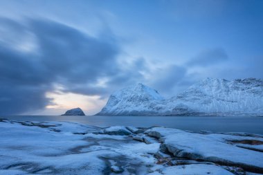 Haukland Sahili, Lofoten Adaları, Norveç. Manzara, uzun pozlu çekim. Dağlar, kayalar ve bulutlar. Okyanus kıyısındaki kış manzarası. Norveç seyahat resmi