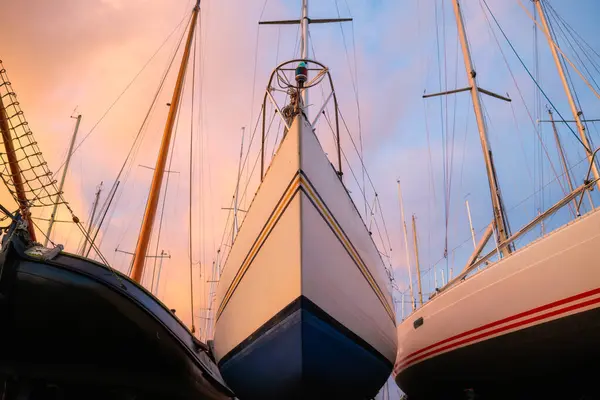 A view of the yachts at the dock. Sailing yachts parked in the marina. Maritime transportation. Dry dock. Yachts at anchorage in the off-season. Transportation composition. Yacht service.