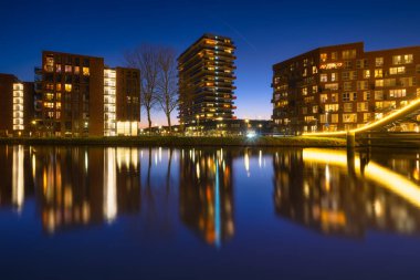 Amsterdam, Netherlands. A cityscape during sunset. A apartment building near the water in the bay. Architecture of the Netherlands. Travel photography.