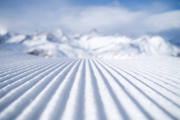 Snow slope for skiing and snowboarding. Velvet. Winter sports. Slope and mountains. Composition in winter time. Wallpaper and background.