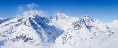 Kış dağı manzarası. Duvar kağıdı ya da arka plan. Gökyüzü açık. Soğuk hava ve buz. Yüksek kayalar ve kar. Dağların manzarası. 