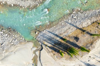Nehir ve ağaçların drone görüntüsü. İnsansız hava aracı görüntüsü. Sarmal nehir ve ağaçlar. Turkuaz dağ suyu. Alberta, Kanada.
