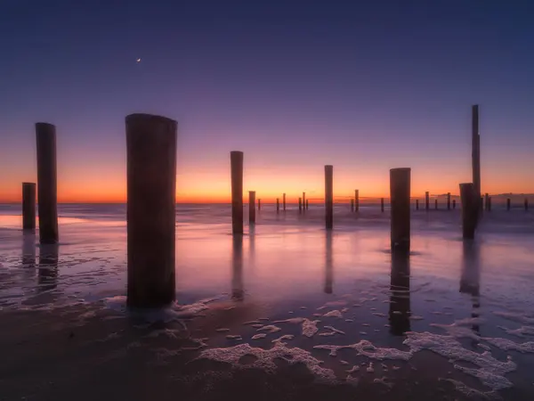 Sebuah Pemandangan Laut Saat Matahari Terbenam Pilar Tepi Pantai Langit — Stok Foto