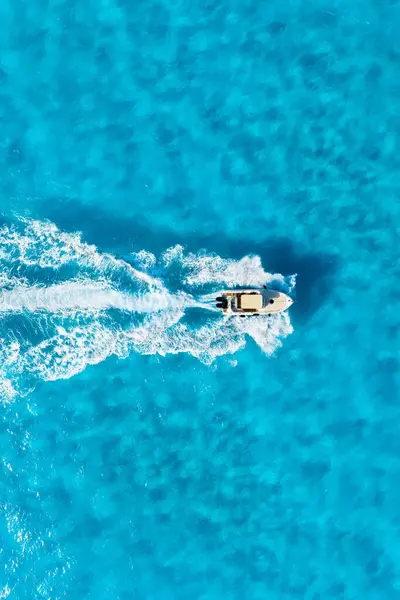 Aerial view on fast boat on blue sea at sunny day. Vacation and leisure. Fast ship on the sea surface. Seascape from the drone. Seascape with motorboat.
