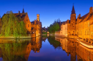 Bruges, Belçika. Şehrin tarihsel bir parçası. Mavi saat boyunca mimari bir manzara. Eski ünlü binalar. Suyun yüzeyindeki yansımalar. Duvar kağıdı, kartpostallar, arkaplan, tasarım için resim.