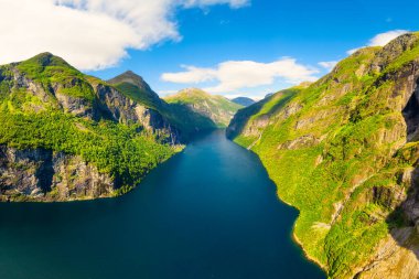 Geiranger Fjord, Norveç. Fiyortlarda doğa. Norveç fiyordunda tekneyle seyahat etmek. İskandinavya. İnsansız hava aracından doğanın görüntüsü. Yedi Kız Kardeş Şelalesi. Norveç 'te yaz tatili ve seyahati.