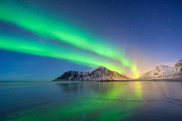Aurora Borealis in Scandinavia. Norway, Lofoten islands. Northern lights over the mountains. Starry sky. Winter landscape on the north. Photo for background, wallpaper, postcards.