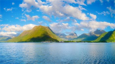 Norveç. Fiyortlarda doğa. Yüksek dağlar ve su yüzeyindeki yansımalar. Kayaların üzerindeki bulutlar. Norveç 'te yaz tatili ve seyahati.