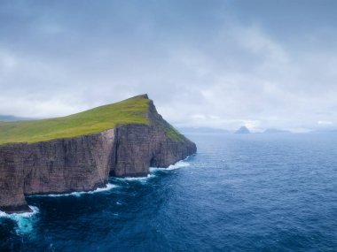 Faroe Adaları, Danimarka. İskandinav doğası. İskandinavya. Otlağın panoramik manzarası, okyanus körfezi ve dağlar. Fotoğraf: arkaplan, duvar kağıdı, kartpostallar.