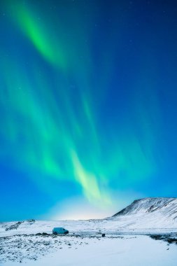 İskandinavya 'daki Aurora Borealis. Norveç, Lofoten adaları. Dağların üzerinden kuzey ışıkları. Yıldızlı gökyüzü. Kuzeyde kış manzarası. Arkaplan, duvar kağıdı, kartpostallar için fotoğraf.