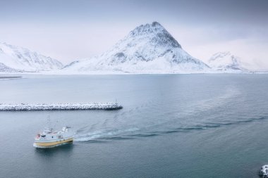 Fiyortta bir balıkçı teknesi. Norveç, Lofoten Adaları 'nın havadan görünüşü. Endüstriyel balıkçılık İnsansız hava aracı görüntüsü. Hava manzarası. Dağlar ve su. Norveç 'in Resmi