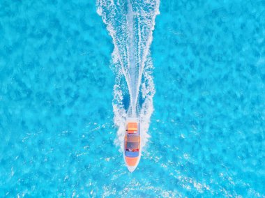 Güneşli bir günde mavi Akdeniz 'de hızlı bir teknenin insansız hava aracı görüntüsü. Tatil ve boş zaman. Deniz yüzeyinde hızlı gemi. Drone 'dan deniz pelerini. Duvar kağıdı, kartpostal, arkaplan. 